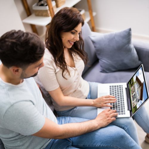 Find a Home Button - Stock Image of Two people on a couch search on a computer - Amy Kristt Lic. Real Estate Salesperson at Warren Real Estate